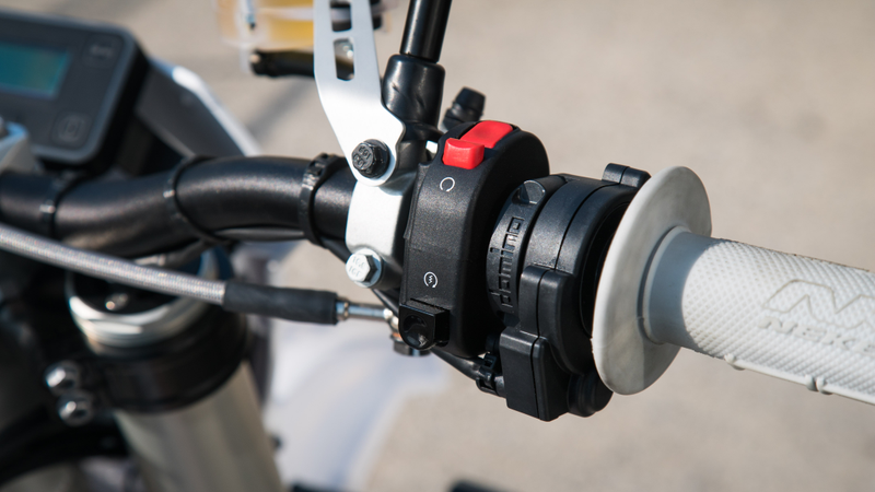 The aforementioned black “starter” button on a fully-electric motorcycle. The red switch is the kill switch.
